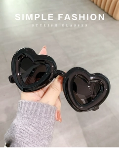 Close-up of heart-shaped sunglasses with black frames and dark polarized lenses
