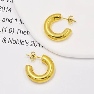 Detailed top-down view of hollow C-shaped gold hoops in high-polished titanium steel
