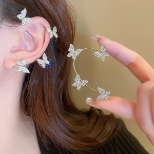 Macro shot of sparkling butterfly ear cuff with rhinestones on a minimalist background