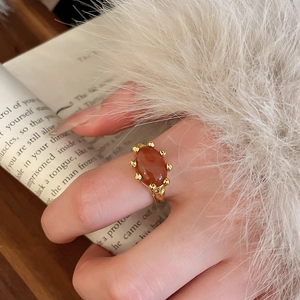 Detail of vintage gold-plated ring with oval red gemstone on textured metal band