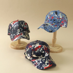 Trois casquettes de baseball camouflage noir et bleu avec graffiti métallisé sur support en bois