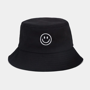 Gros plan sur le bob en coton noir avec broderie smiley blanc de style minimaliste