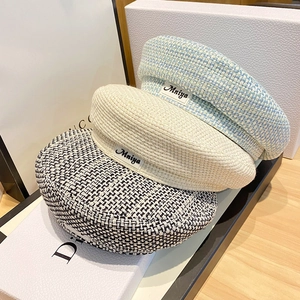 Chic tweed beret hats in blue and beige with woven texture and stylish brand label