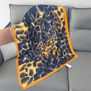 Elegant navy blue linen scarf with abstract yellow patterns draped on a sofa
