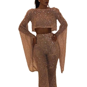 Champagne gold two-piece sequin set featuring long sleeve crop top and flared trousers