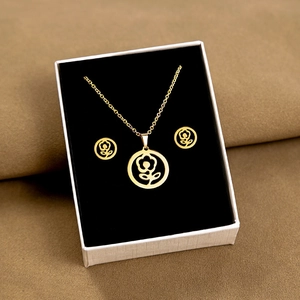 Detailed view of golden floral necklace and earrings set in a white gift box