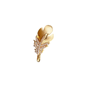 Golden feather brooch featuring brushed metal texture and sparkling zircon crystal inlay