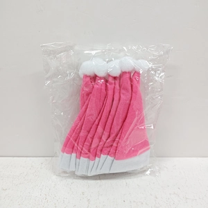 Detail von rosa und weißen Plüsch-Weihnachtsmützen in Verpackung für Besteckdekoration