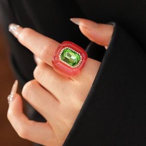 Détail macro d'une bague vintage en résine avec pierre verte taille émeraude et diamants