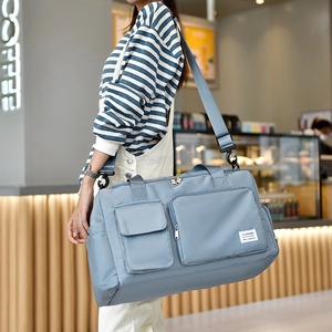 Grey-blue waterproof fitness bag with wet-dry separation and shoe compartment shown on model