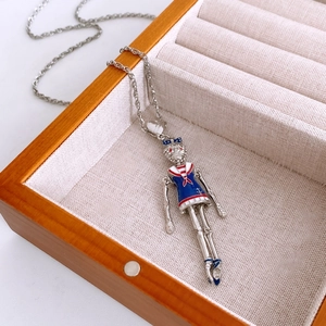 Detail of vintage enamel skeleton pendant on silver chain inside a wooden jewelry box