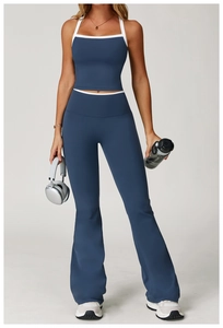 Detail of high-waist flared leggings with contrast white trim and halter top in blue