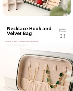 Detail of necklace hooks and elastic pocket inside dark green velvet jewelry box