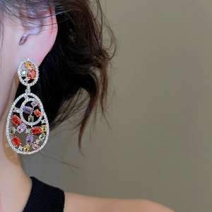 Detailed view of long oval drop earrings with multicolor crystals in a gold-plated finish