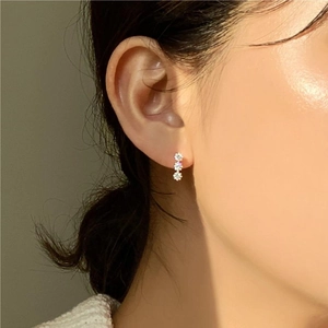 Macro shot of a 925 sterling silver ear stud featuring three vertically aligned zircons