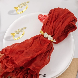 Macro view of gold heart arrow napkin ring with rhinestones on a red napkin