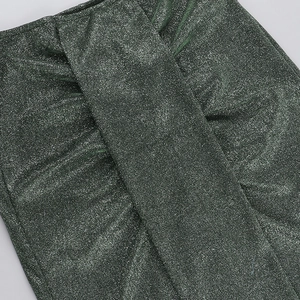 Detailed macro view of dark green metallic knit fabric with shimmering wire and soft texture