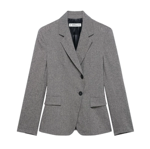 Close-up of grey textured blazer showing double button closure and front flap pockets