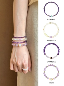 Detailed view of natural amethyst and prehnite beaded bracelets on a model's wrist
