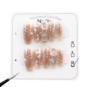 Handmade butterfly press-on nails with pearl and silver accents on long coffin shape
