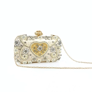 Detailed view of champagne evening bag with heart rhinestone and pearl embroidery