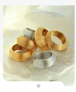 Close-up of gold and silver multi-layer striped rings on a pearlescent shell tray