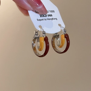 Macro shot of layered enamel C-shaped hoop earrings made of 925 sterling silver