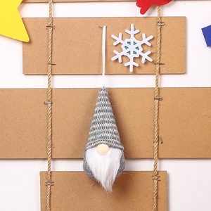 Close-up of a Christmas gnome ornament with a striped knitted hat and white beard