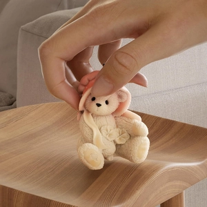 Close-up of small bear sculpture with lily of the valley showing realistic fur texture