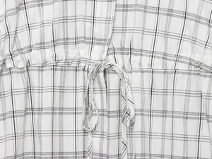 Détail macro de la taille réglable avec cordon sur la veste bomber à carreaux