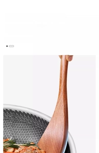 Close-up of long-handled ebony wood spatula matching perfectly with a honeycomb frying pan