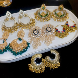 Detailed macro shot of bohemian ethnic earrings featuring hollow drop pearls and tassels