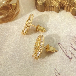 Macro view of gold portrait earrings with sparkling micro-inlaid cubic zirconia
