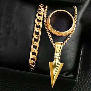 Detailed view of hip hop gold chain bracelet, arrow necklace and ring set on black leather