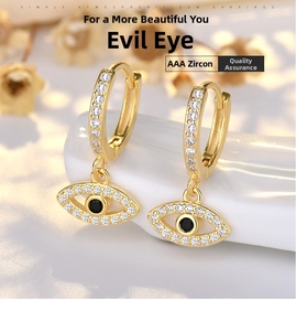 Dettaglio di orecchini Evil Eye dorati con zirconi AAA bianchi e pietra centrale nera