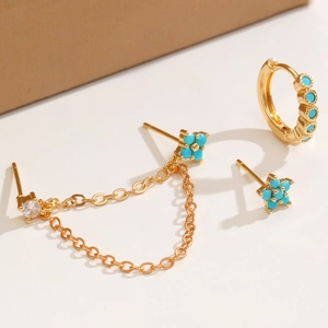 Detailed view of gold plated chain stud earrings with sky blue stones and zircon accents