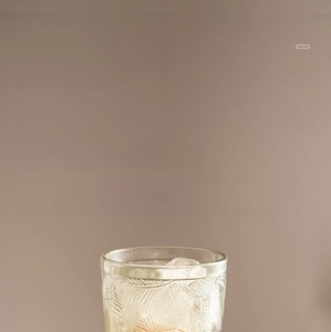 Detailed relief of vintage crystal wine glass with embossed leaf textures and clear ice cubes