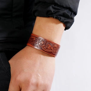 Vintage brown leather bracelet with Nordic totem embossing for men on a wrist