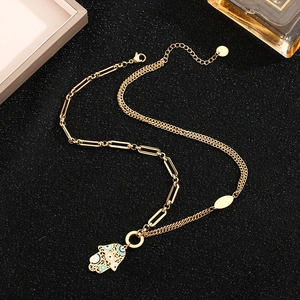 Golden double layer necklace featuring Hamsa Hand pendant with blue and white eye pattern
