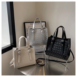 Quilted tote bags for women in white, silver, and black on a minimalist metal table