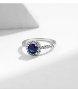 Macro shot of S925 silver ring featuring deep blue gemstone with halo diamond setting