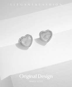 Dettaglio degli orecchini a cuore in argento S925 con intarsio in marmo grigio elegante