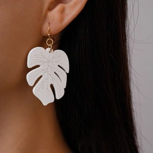 Detail of white monstera leaf earring featuring realistic leaf veins and golden hook