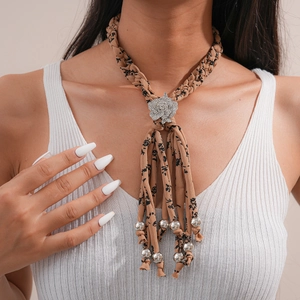 Détail du collier rétro en tissu avec strass et pendentif métallique sur un mannequin