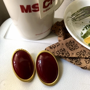 Detailed view of vintage oval red resin earrings with gold edges on s925 silver needles