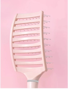 Nahaufnahme der rosa gebogenen Skelettbürste für Kopfhautmassage und Volumen