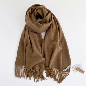 Dettaglio di sciarpa marrone stile cashmere con frange morbide e trama pregiata