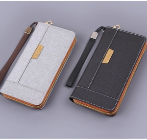 Gros plan sur des pochettes pour hommes en toile grise et noire avec fermetures éclair en métal