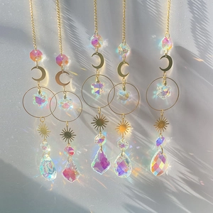 Detail of five crystal suncatchers with gold moon and sun motifs creating rainbow reflections