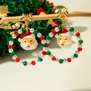 Close-up of festive Christmas earrings with colorful beads, bow, and Santa Claus pendant
